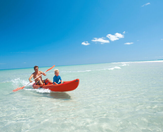 Two people on a boat in shallow water