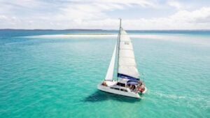 sailboat glides along clear blue waters in the fraser coast